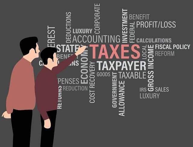 Image of two men pointing and looking at tax words