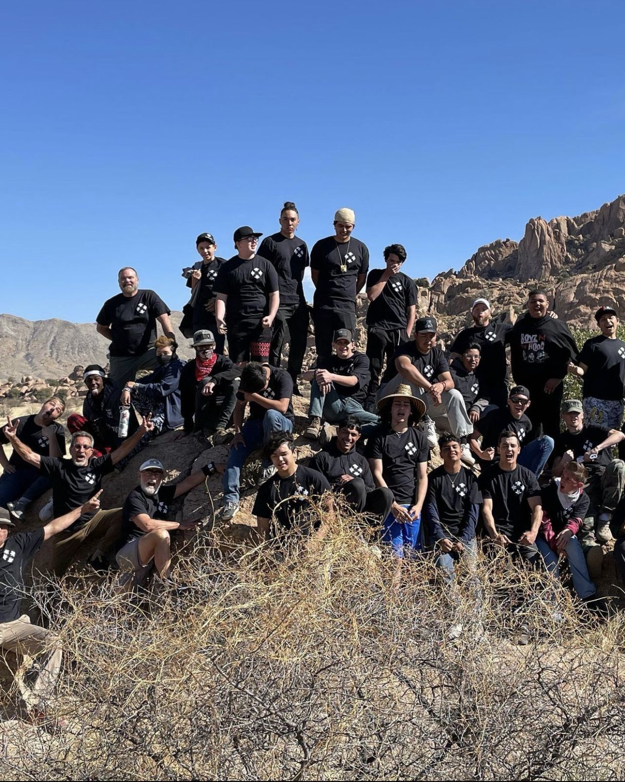 BTM youth and mentors huddle for a group picture at the base of the Dragoon Mountains