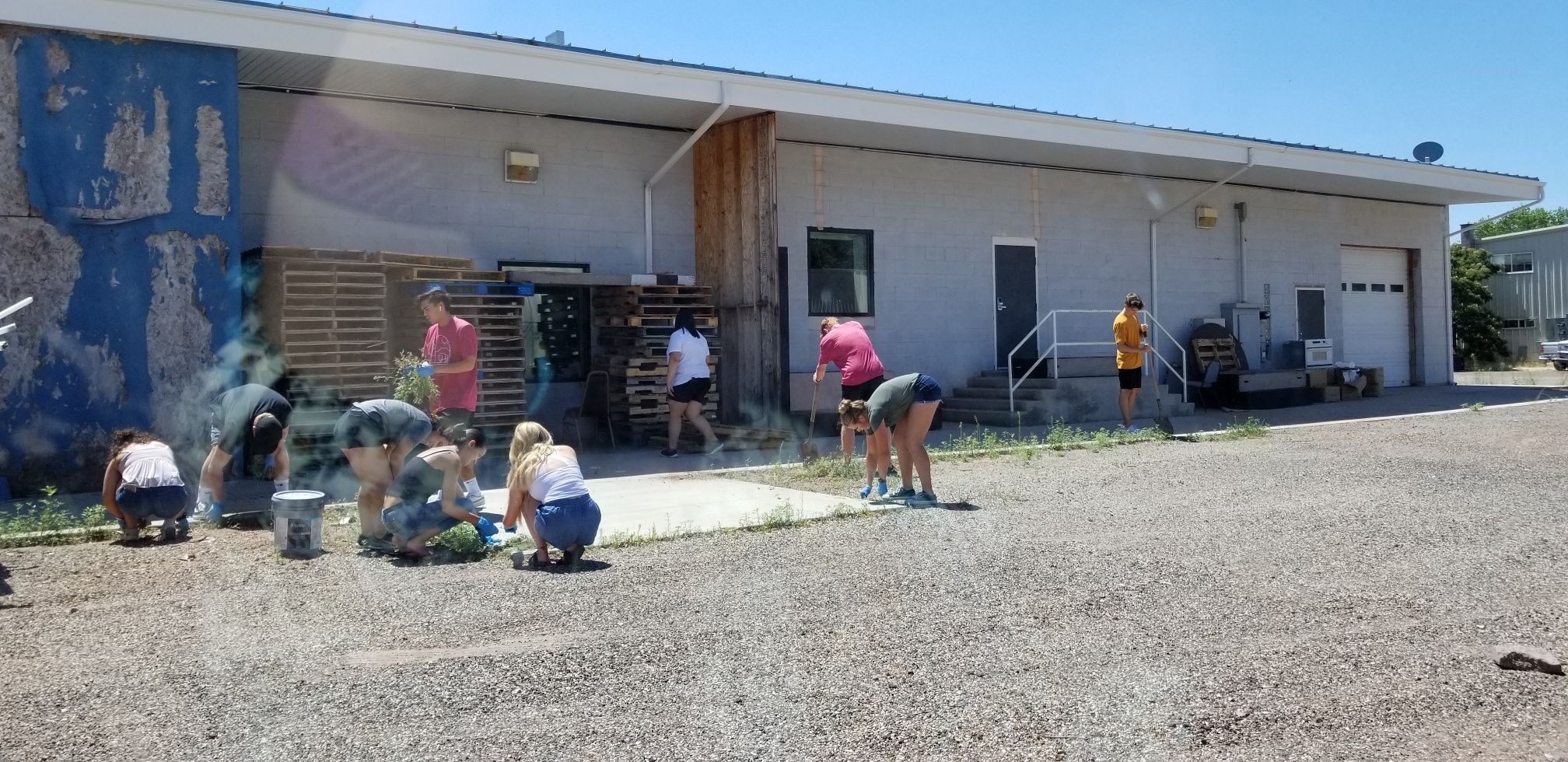 Volunteers improve the grounds of a health clinic in polygamist community