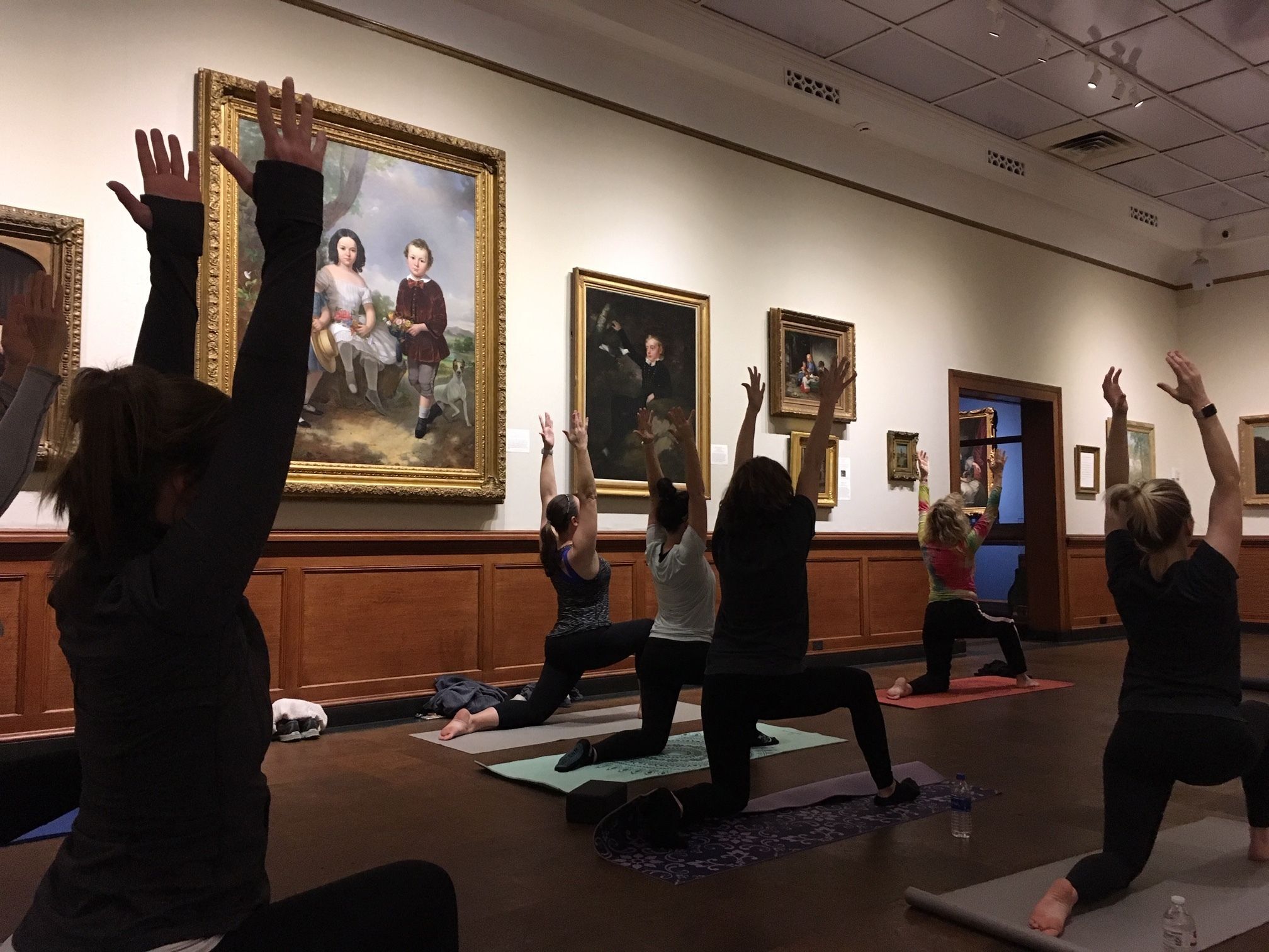 People doing yoga poses in American art gallery