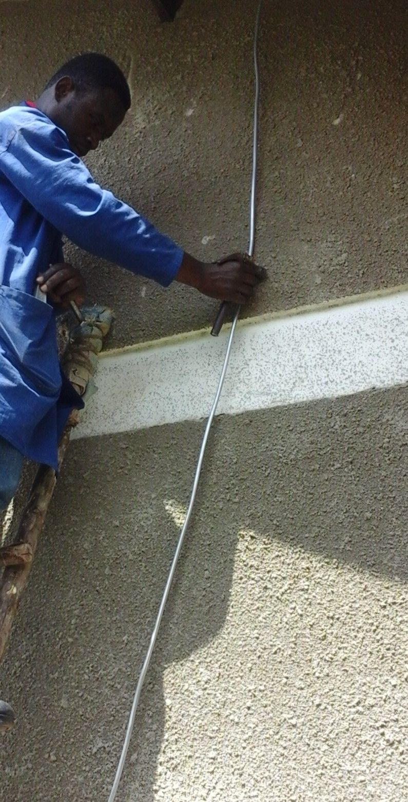 Installing down-conductors which carry lightning current from the lightning rods harmlessly to the earthing/grounding rings buried in trenches around each building