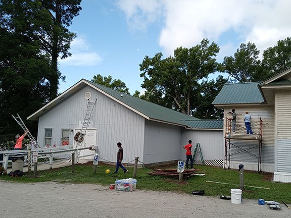 Mission Serve volunteers painting the Country Store with supplies provided by Painting A Brighter Future grant.