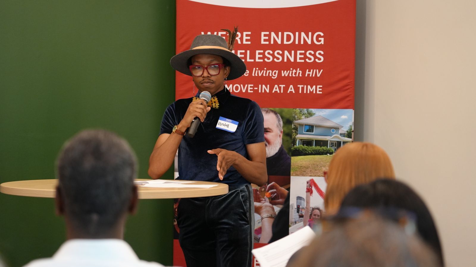 A person stands with a microphone