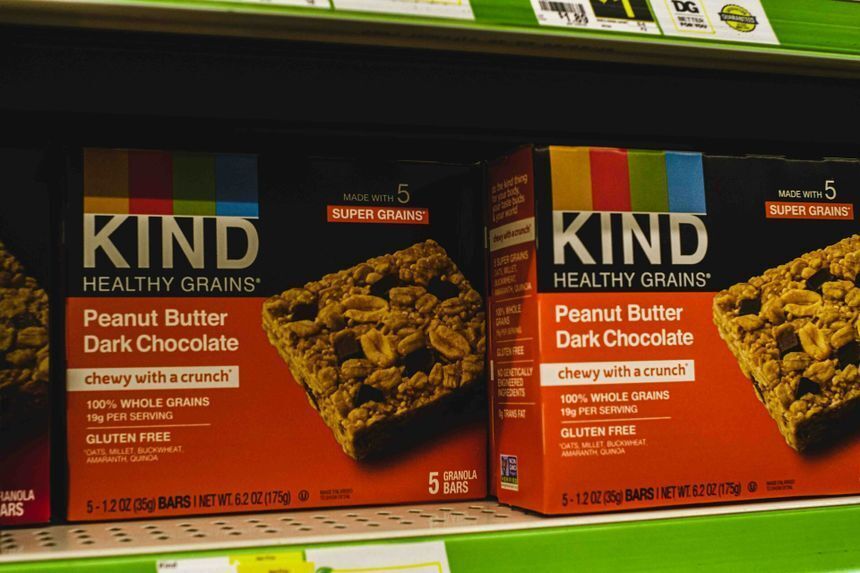 Two KIND cereal boxes on a store shelf display mismatched orange brand colors, highlighting the critical need for brand color management.