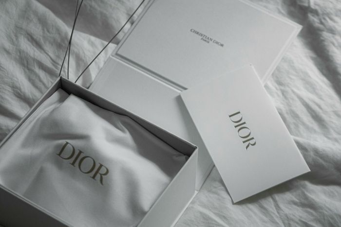Minimalist product packaging showcasing a premium white rigid box with a matching branded dust bag and insert card