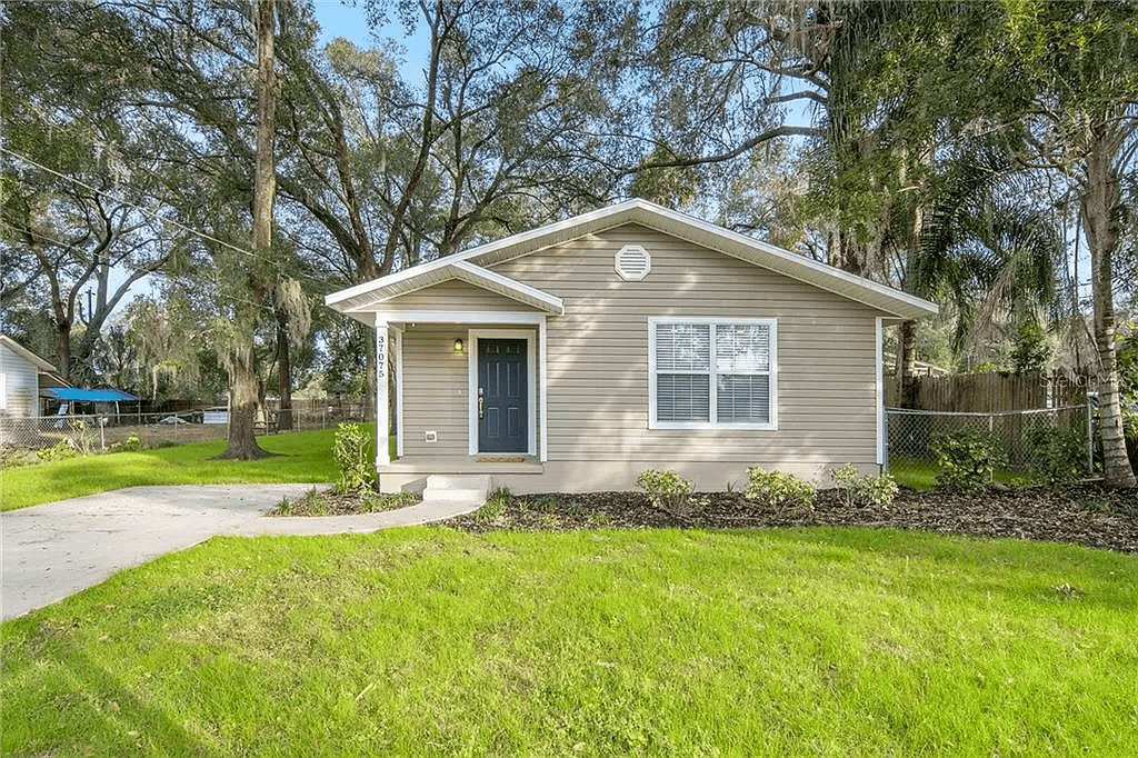Completed Habitat for Humanity home in Pasco County, Florida, with a covered entry, driveway, and landscaped front yard.