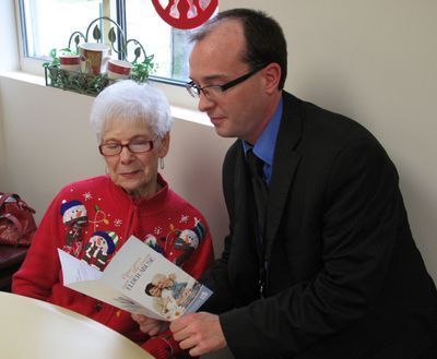 Two adults reading a shared brochure.