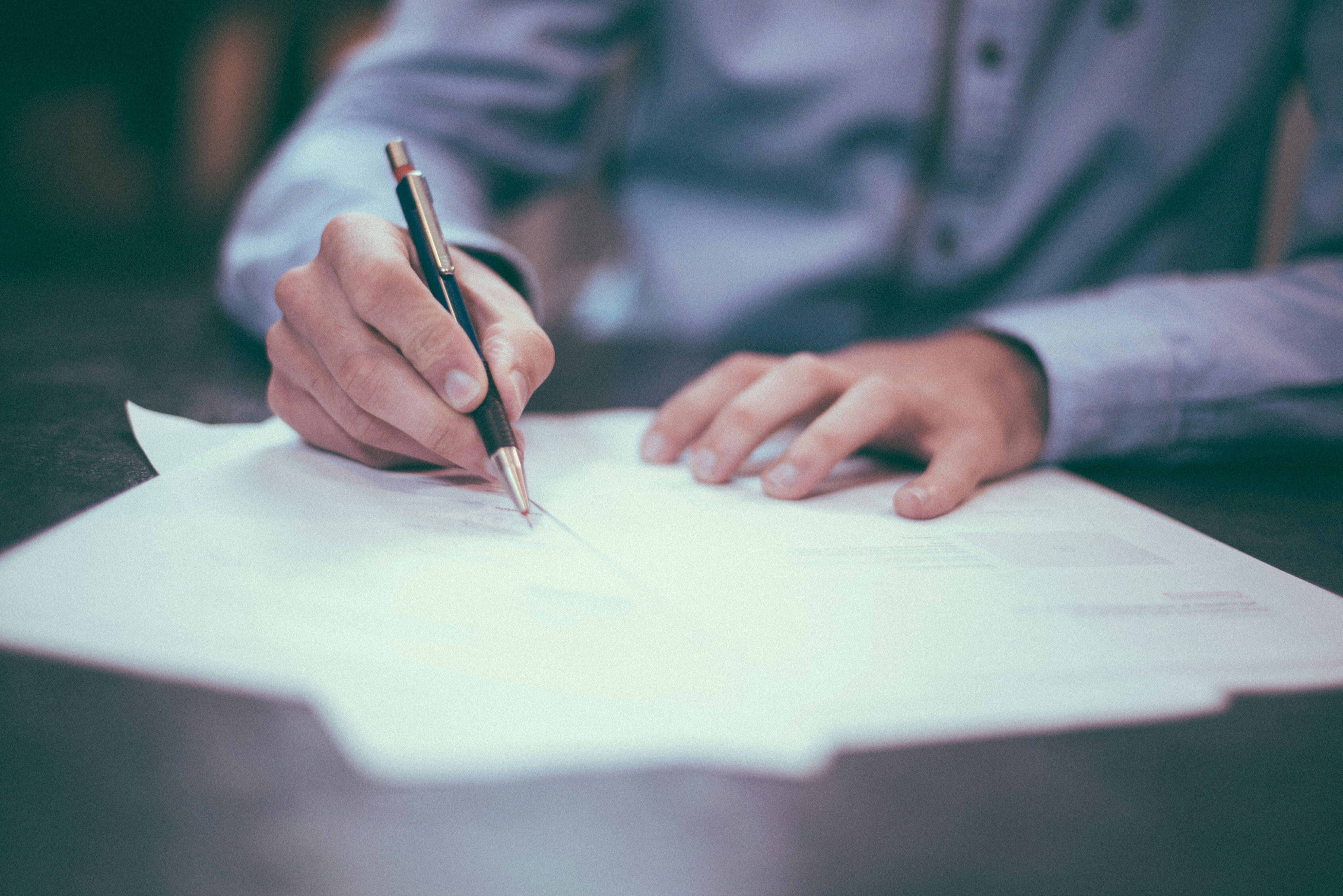 Businessman holding pen above papers