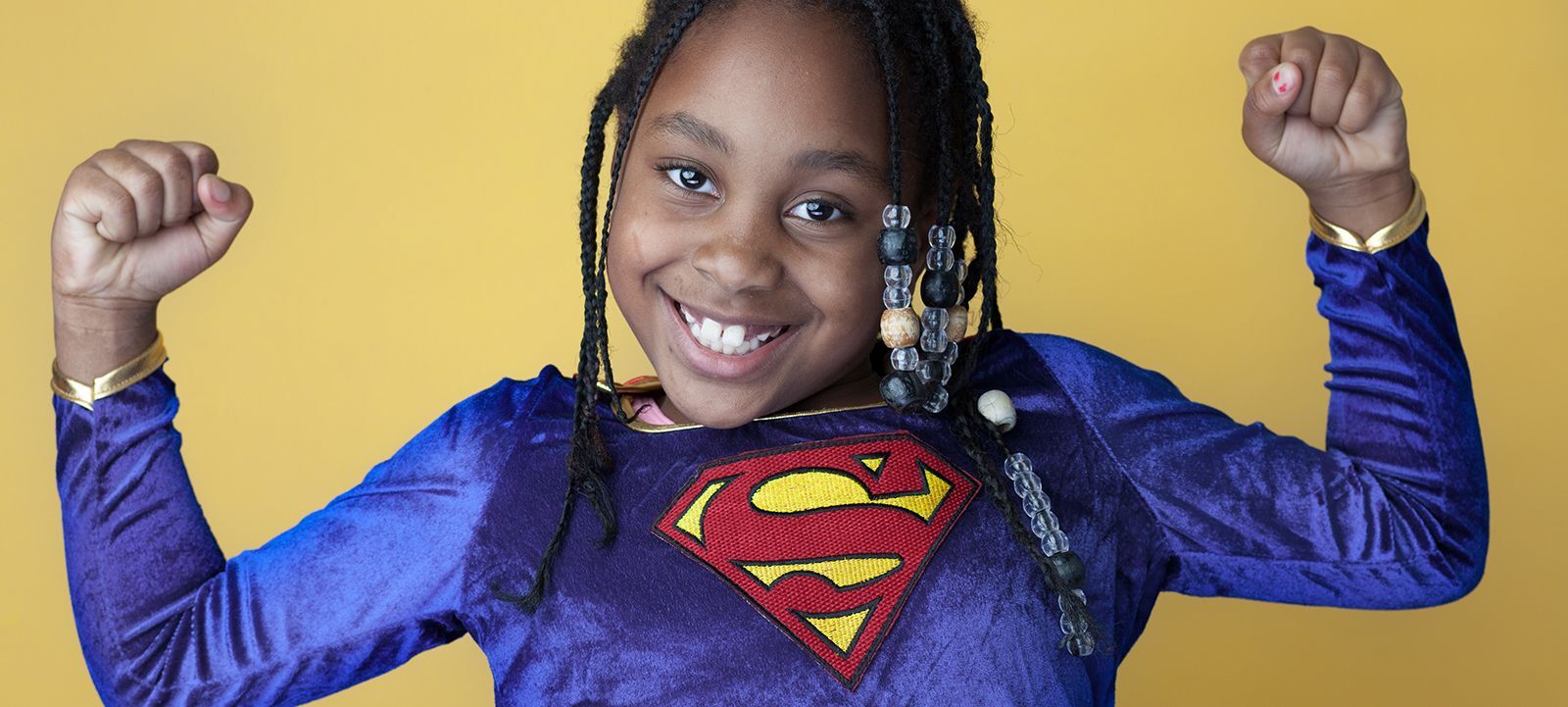 Little girl wearing a superman costume.