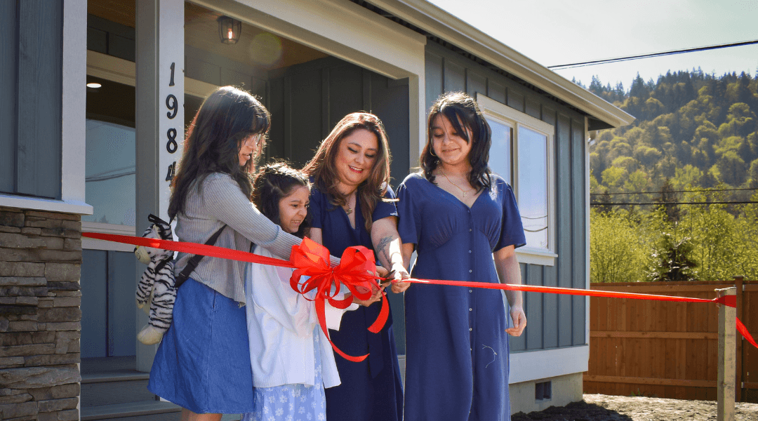 Picture:Skagit Habitat for Humanity's 44th Homebuyer, Dayse, cutting the ribbon in front of her new home at her Home Dedication Ceremony.