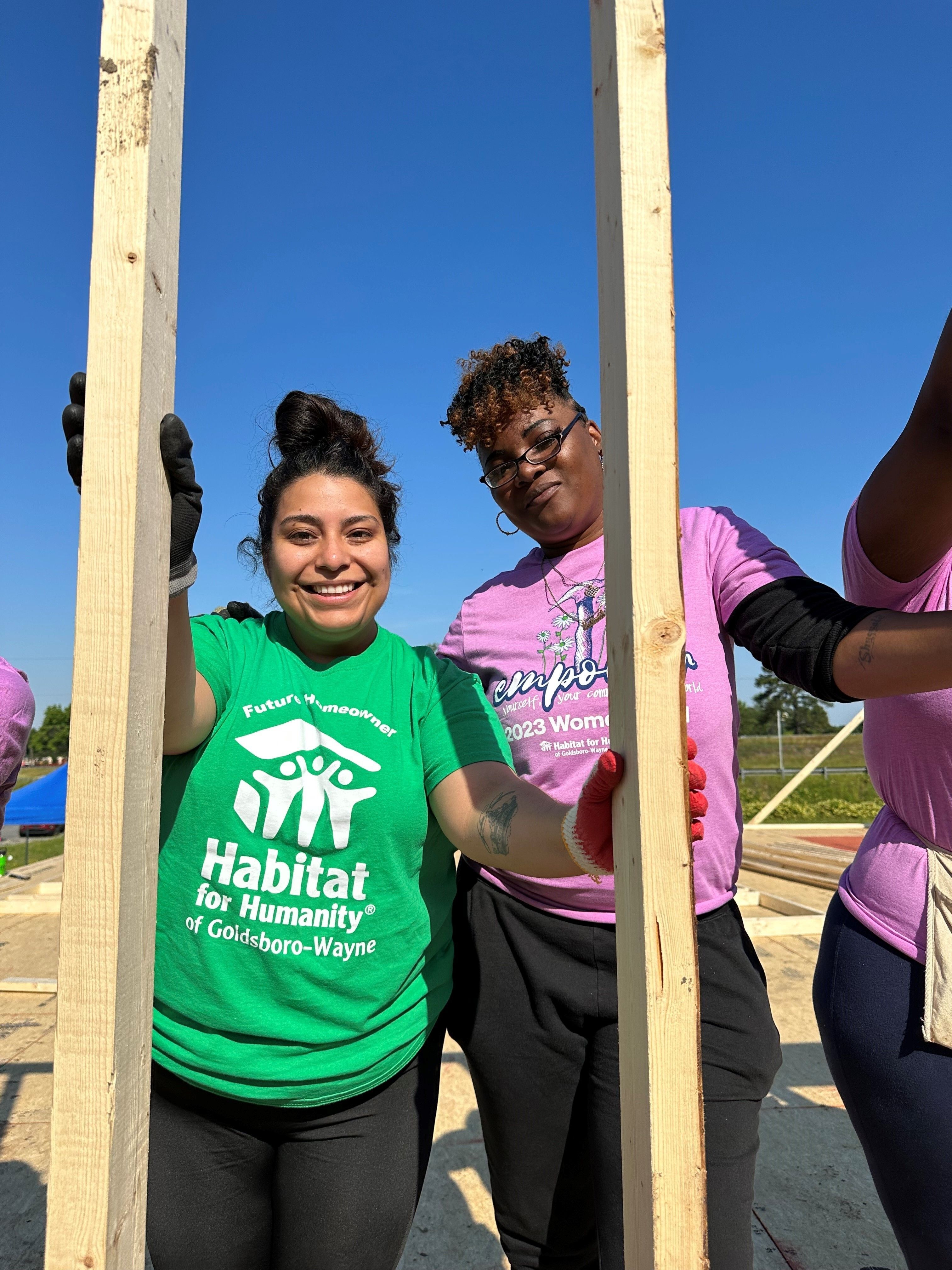 Two Habitat homeowners work together on a new home.