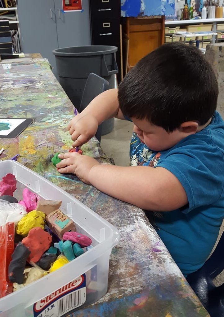 little boy playing with clay