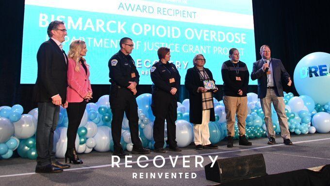 People on a stage receiving an award.