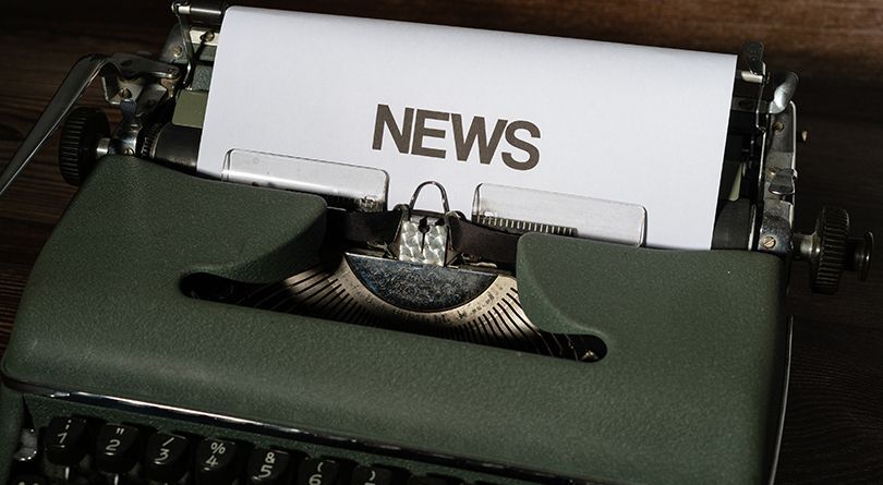 A green typewriter with News typed on it 
