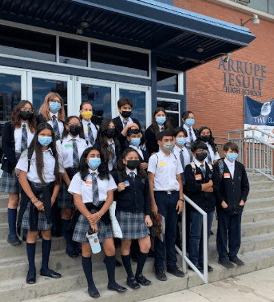 A group of 8th grade students standing in front of Arrupe Jesuit High School