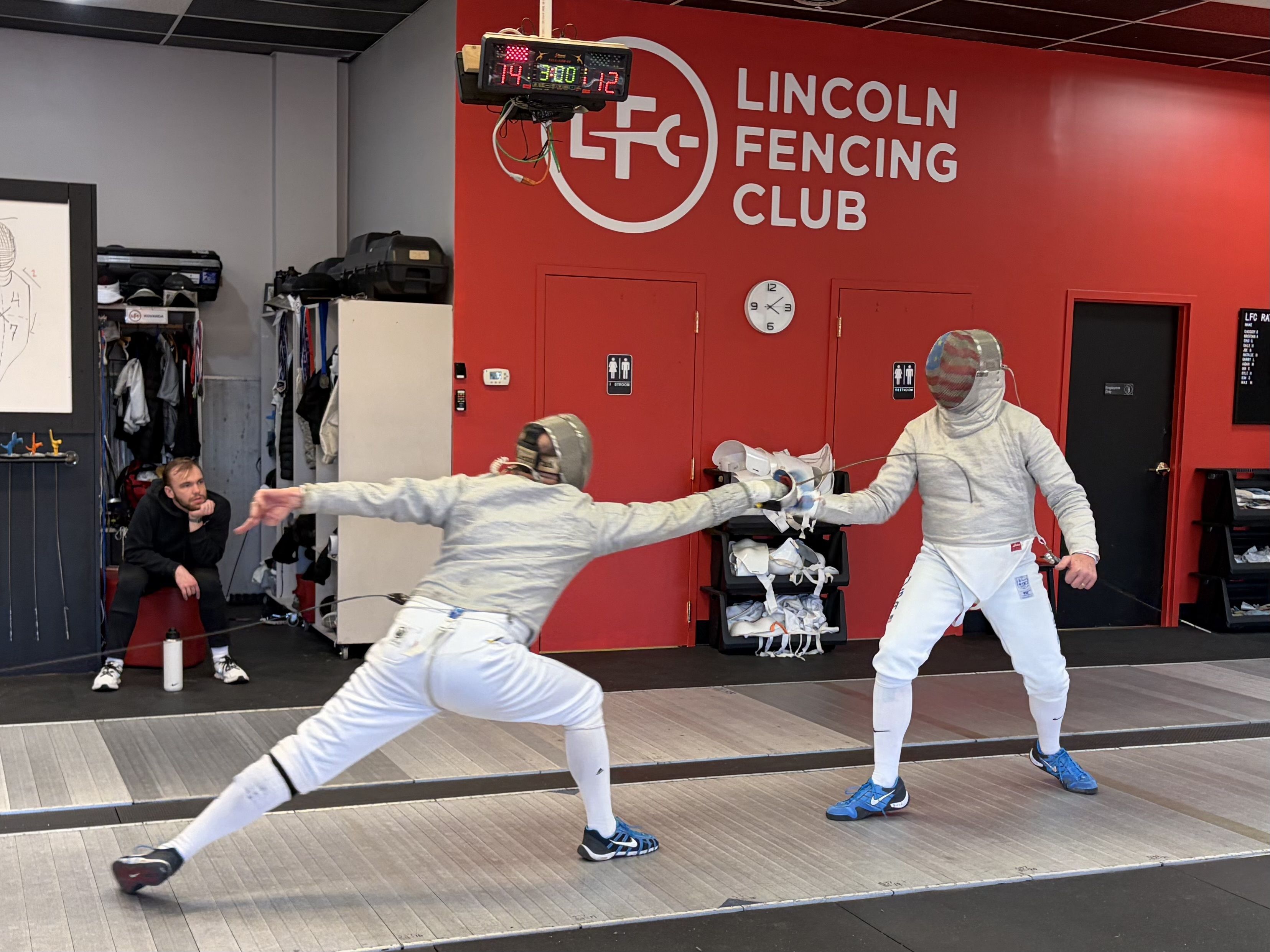 A sabre fencer lunges for the bout-winning touch