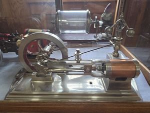 C. Cretors & Co. .5 hp steam engine, made 1906 with silver, copper, and red details, with one fly wheel.