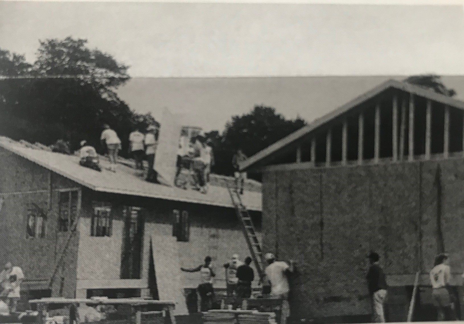 A black and white image of two Homecoming houses being constructed on Bowman Field. 