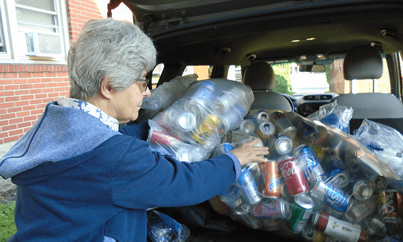 Sister Christine Kosin loads up the car with aluminum cans for recycling.