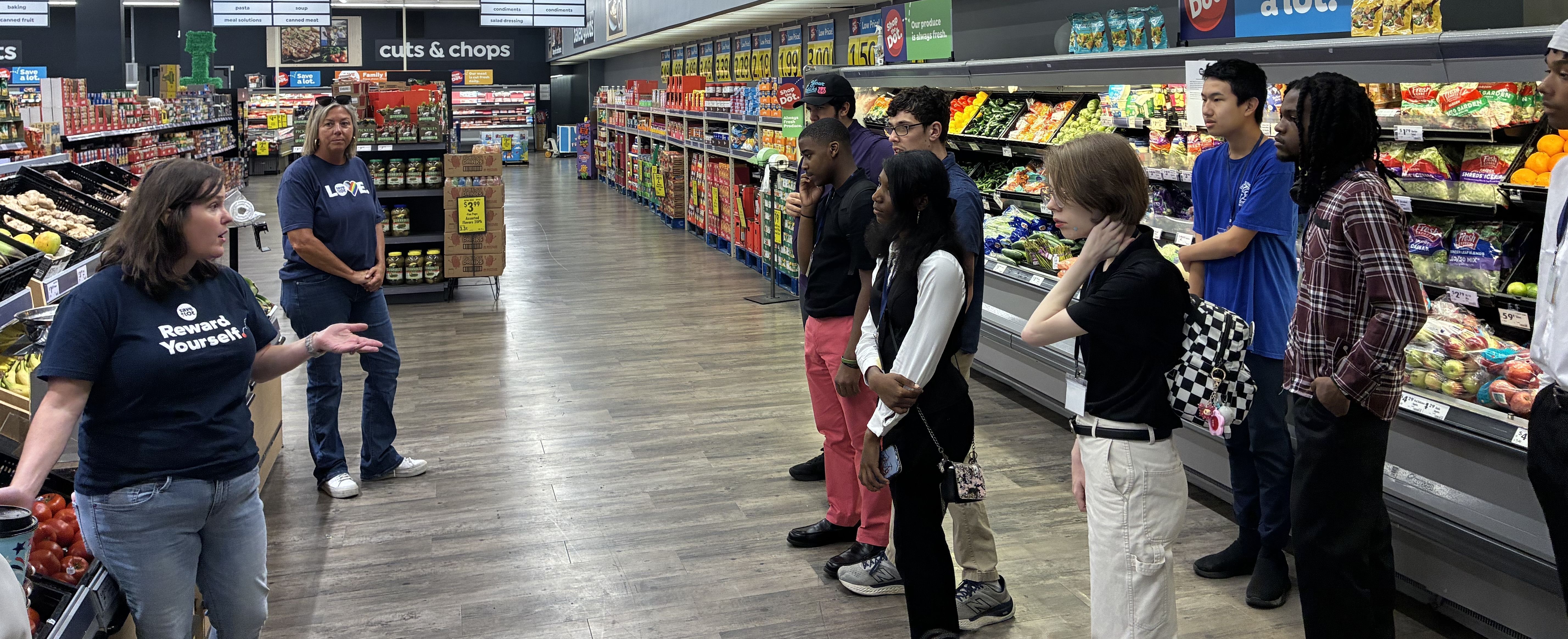 students at a grocery store talking with the manager