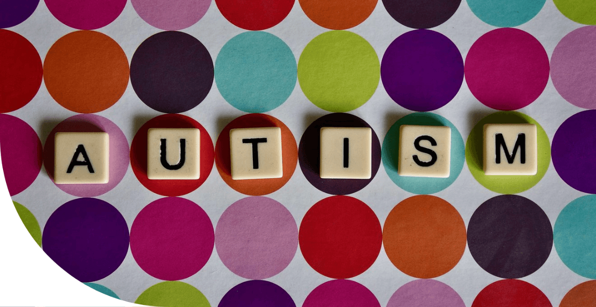 autism spelled out in tiles letters on polka dot background