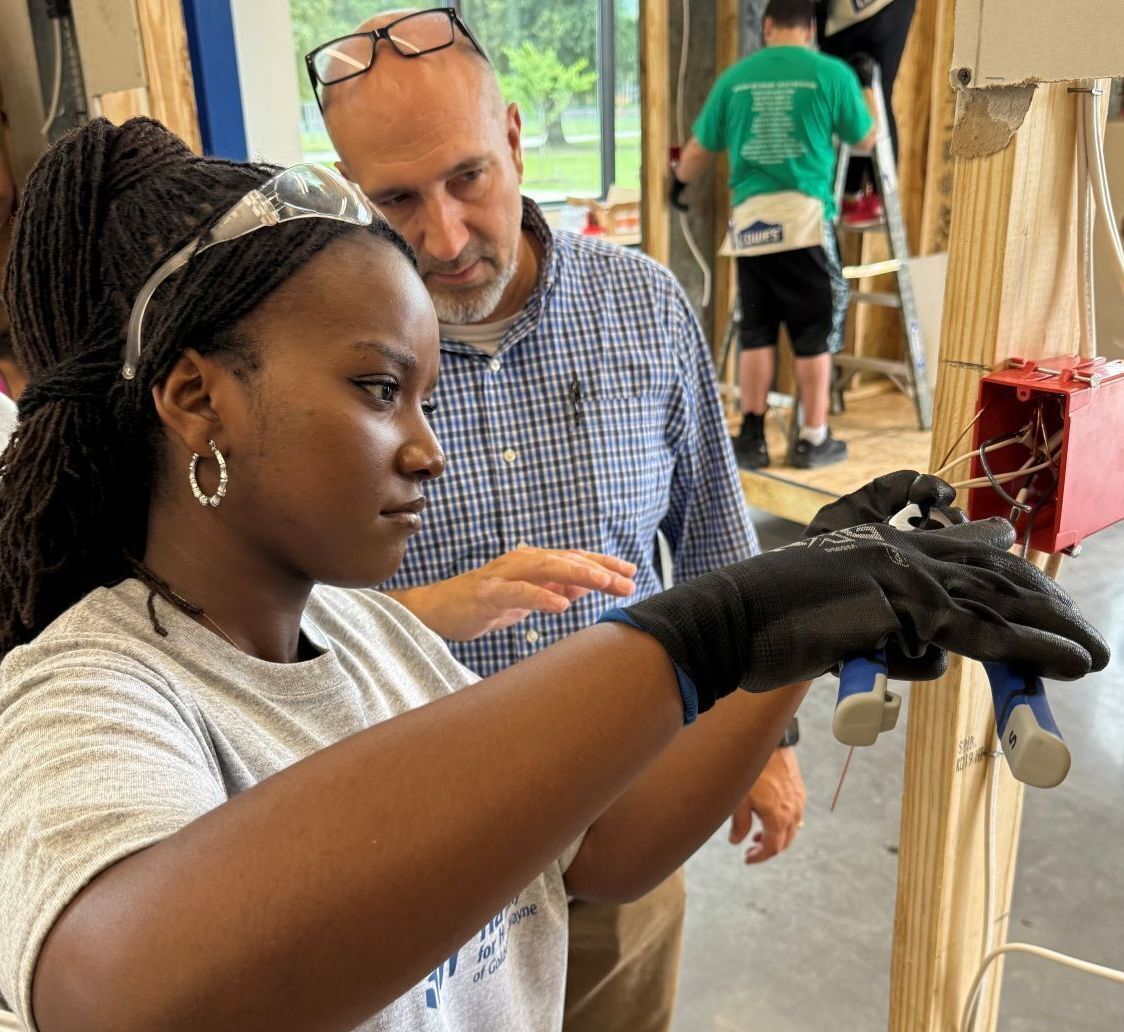 2025 construction camp student runs electrical lines under the instructor's watchful eye.