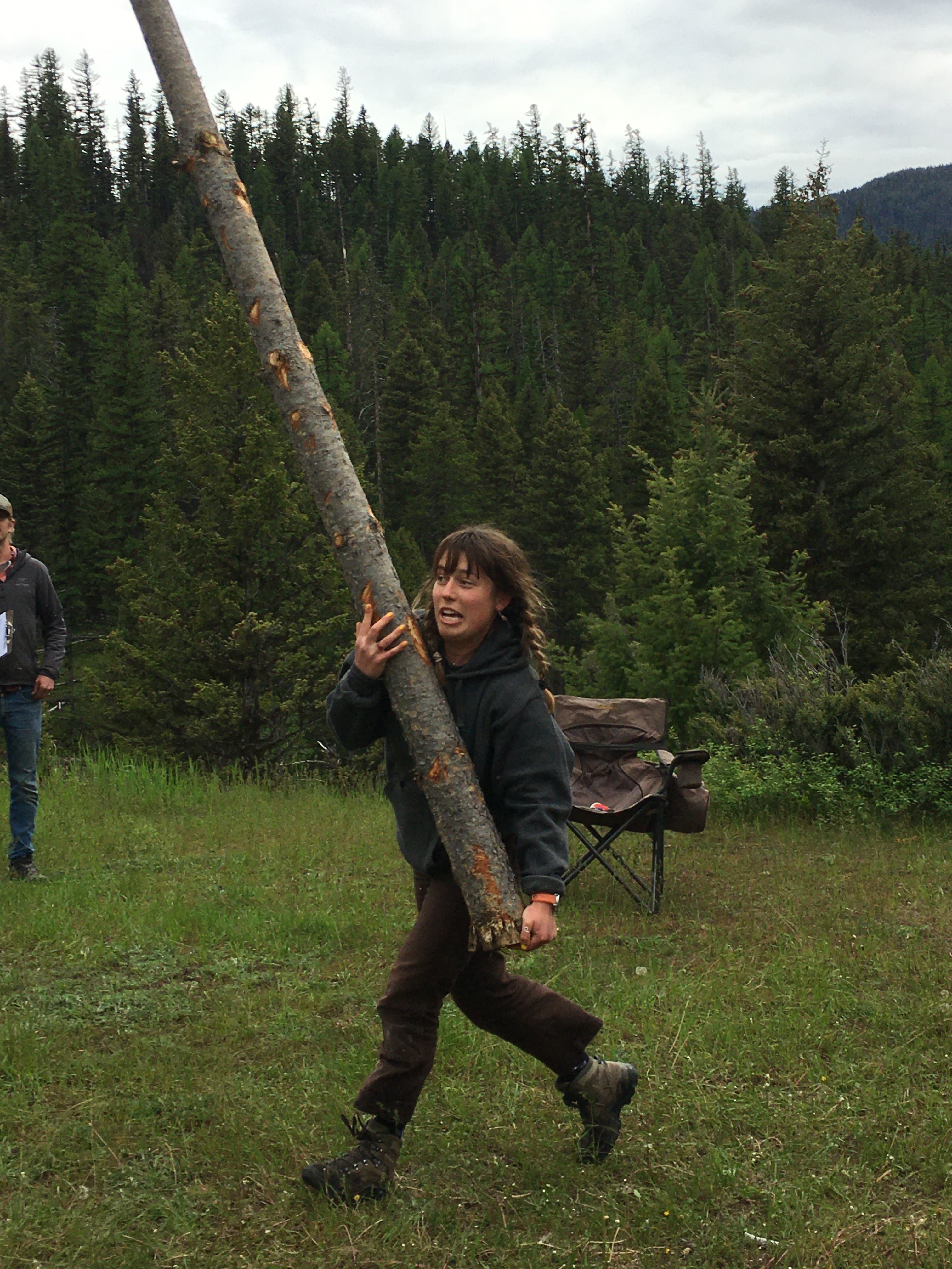 A crew member holds a large log vertically as they run. This is an example of one of the the athletic feats mentioned in the blog.