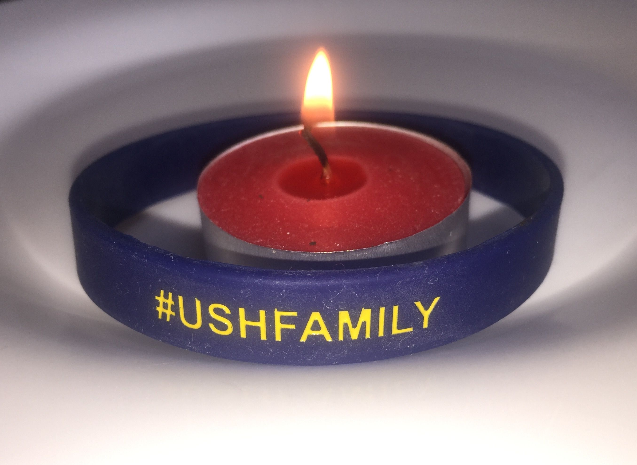 Picture of a candle with an Usher Syndrome Coalition bracelet around the candle.