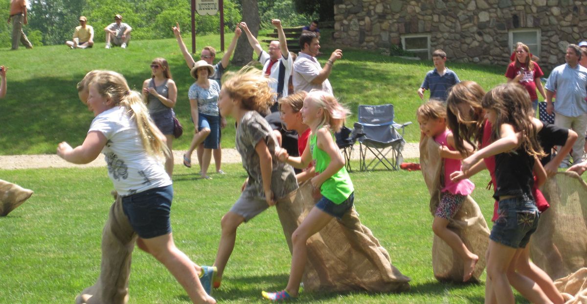 Children participate in a 3-legged race on the Village Green.