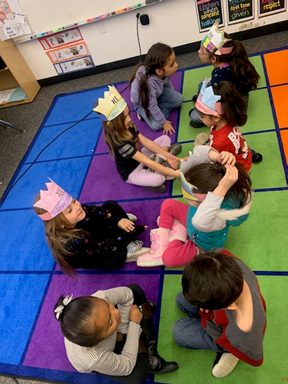 Children sitting in a circle on colorful mats in a classroom