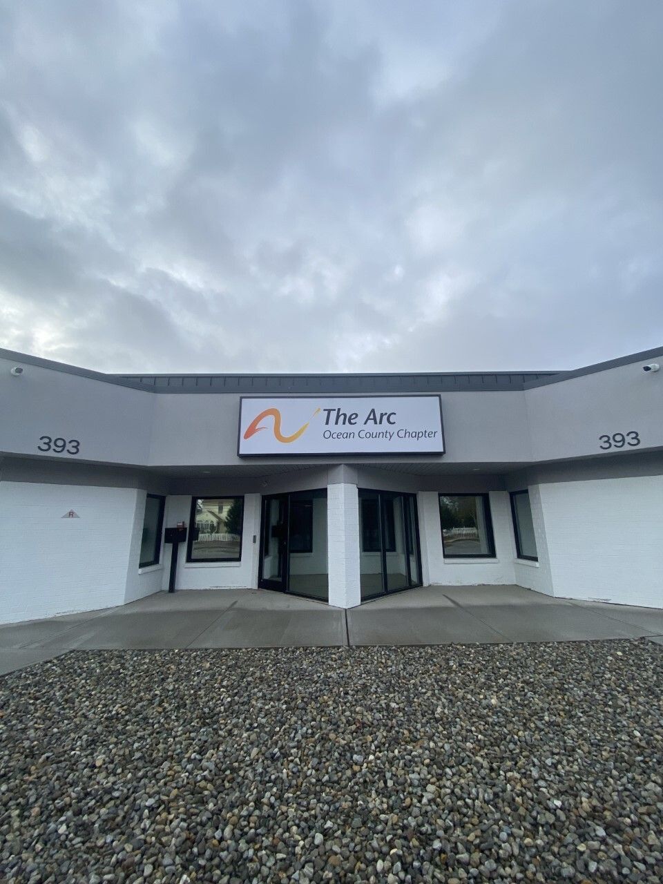 Photo of the front of a building with The Arc logo and the number "393:" 