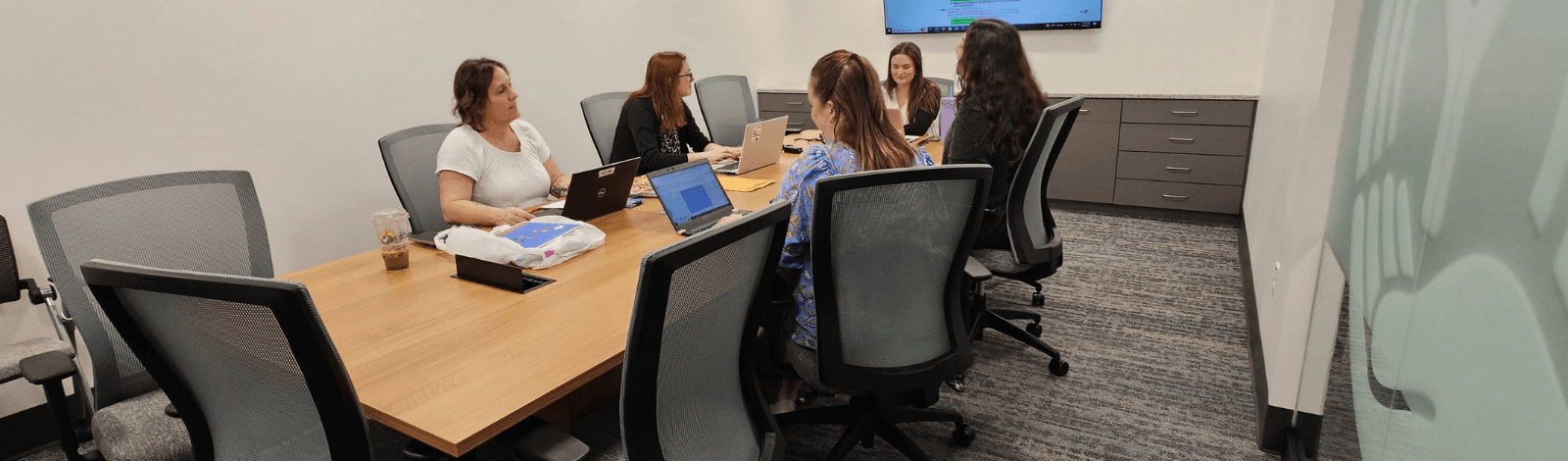 Image of professionals seated around a table on a conference room, while working with a United Way consultant.