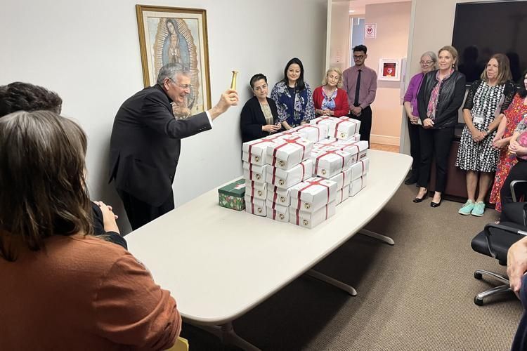Bishop Barbarito blesses boxes of joy filled by employees of the Diocese of Palm Beach.