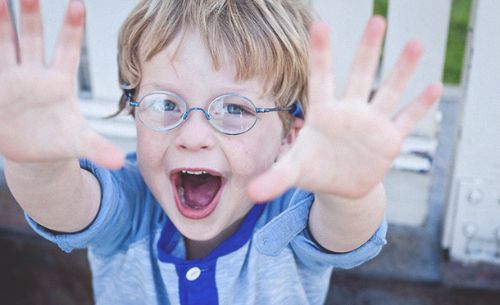 Photo of little boy with blue glasses and a blue shirt