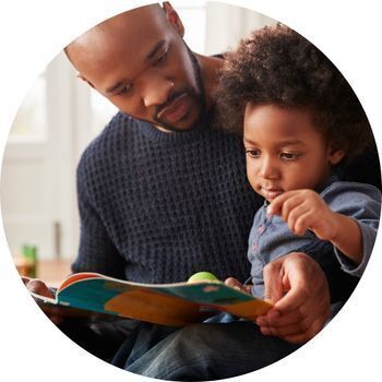 Father and toddler share book together