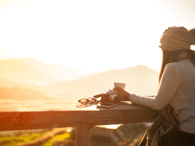 woman looking at sunset over mountains