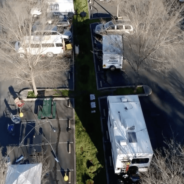 RVs and Cars parked in a manage homelessness safe parking site. Viewed from above.