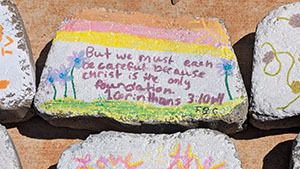 Painted brick with colorful artwork and handwritten Bible verse