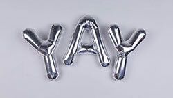 Silver balloons that say Yay!