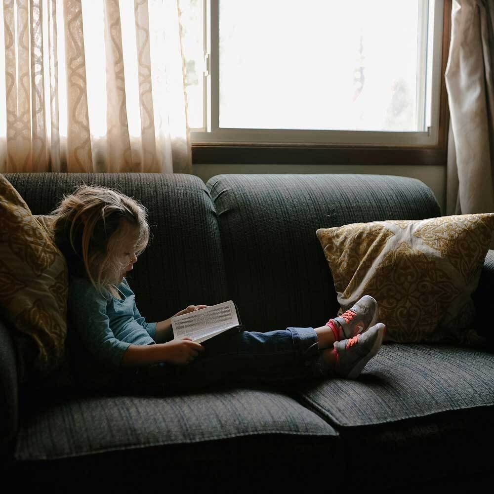 Child reading on a couch