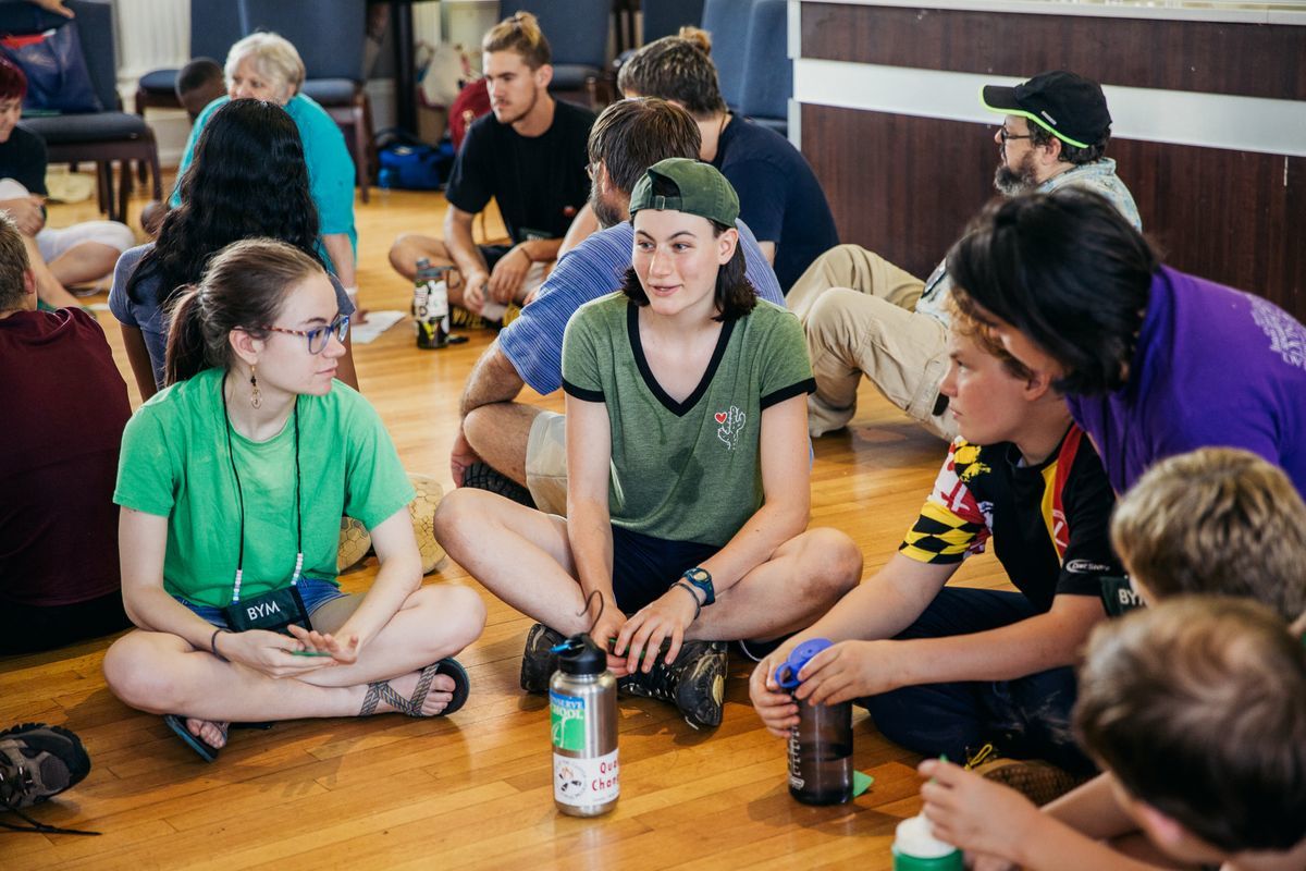 YFs sitting cross-legged on the floor during a workshop discussion