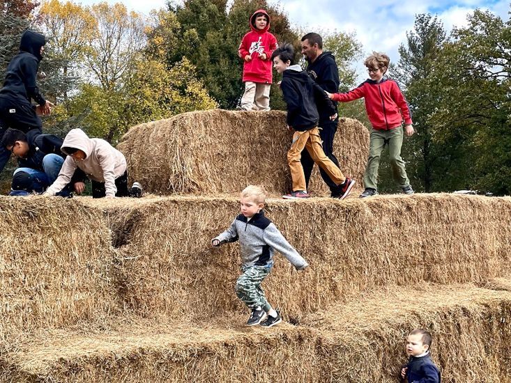 Boys run around the top of the Hay Pyramid at Snipes Farm Fall Festival