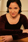 Pamela Sabaugh, A women in a brown shirt, with her arms crossed over her chest and posing and smiling at the camera.