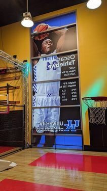Basketball player shooting ball into hoop wearing white uniform with blue text