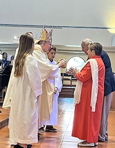 Couple celebrating 69 years of marriage present the offertory gifts to Bishop Barbarito