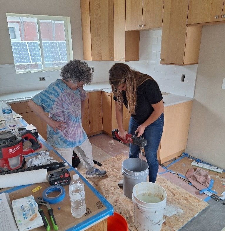 Addison working on her house with a volunteer.