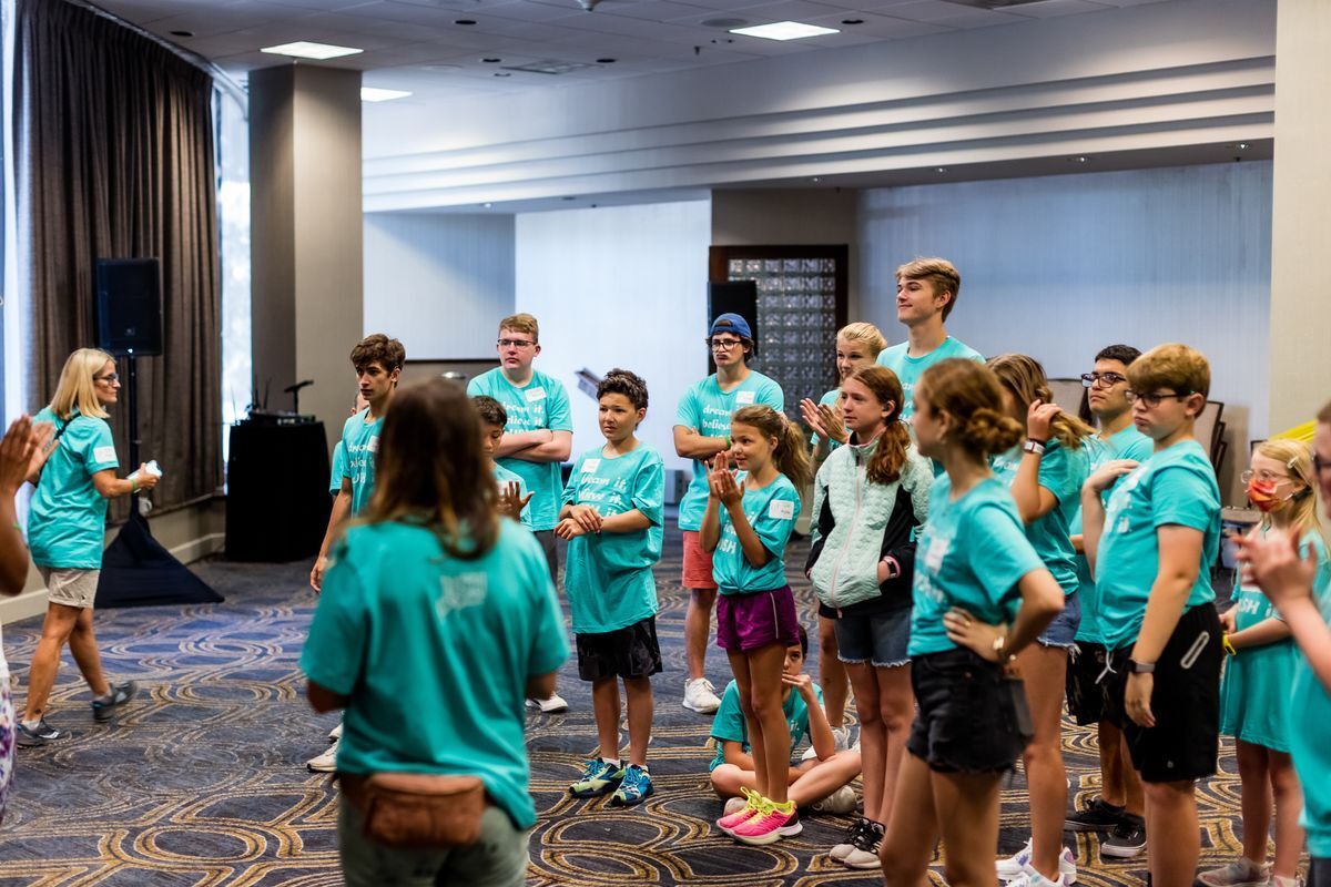 An action shot of the USH Youth crew standing together watching someone, off screen, while they were learning the steps to a dance that they would perform later on.