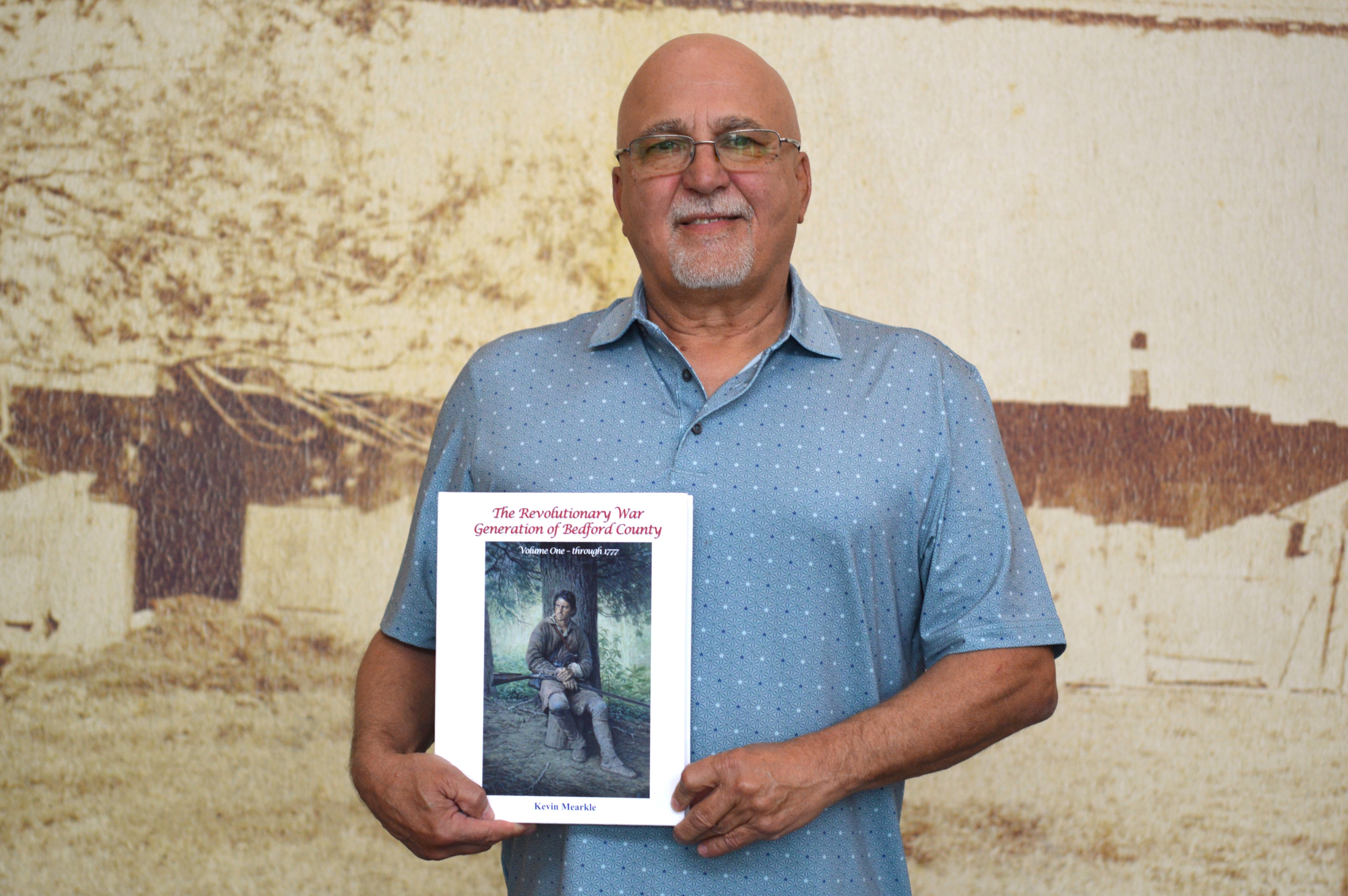 Portrait of author Kevin Mearkle holding ihs book