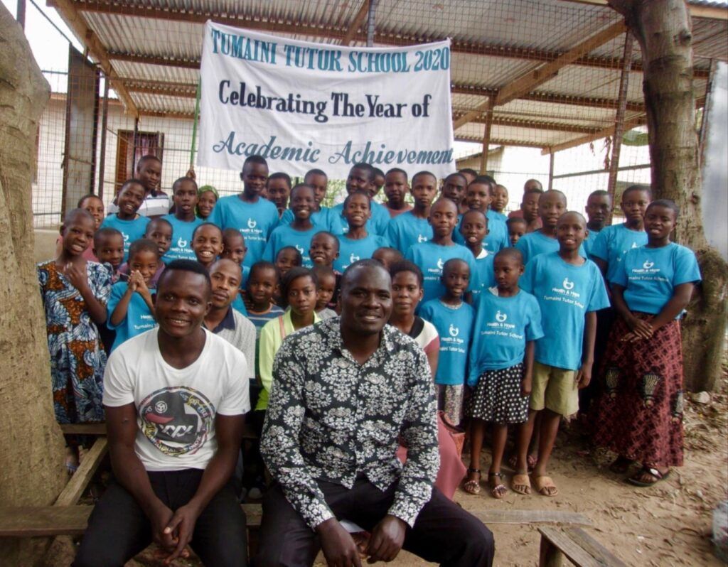 Two teachers and their students smiling.