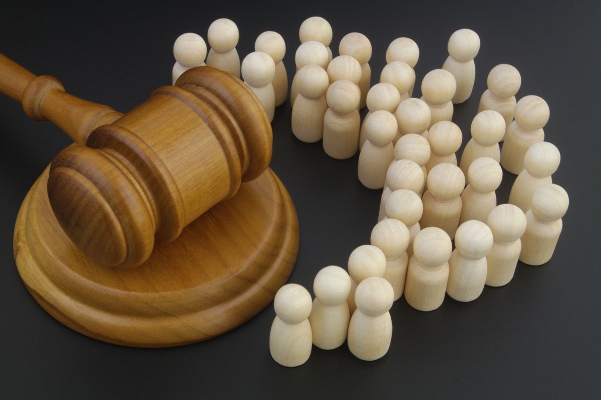 Judge's gavel surrounded by white pegs in shape of people, suggesting public trust in the courts.